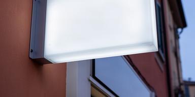 Cassonetto luminoso bifacciale a LED installato sulla facciata di un negozio a Loano