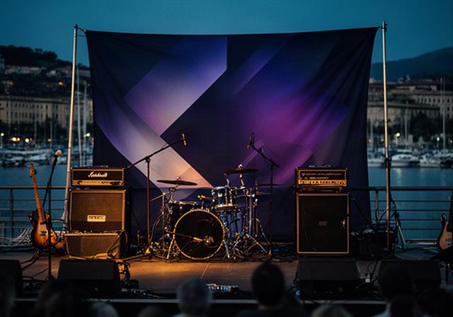 Concerto al Porto di Loano con backdrop stampato dietro gli strumenti sul palco